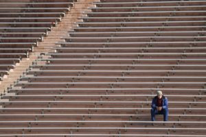 A fan watches the women’s lacrosse game against Columbia on Saturday from the bleachers of Schoellkopf Field. (Ben Parker/Sun Assistant Photography Editor)
